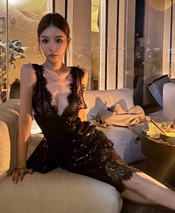 Détail d'une robe noire à paillettes avec dentelle et décolleté en V sur un mannequin