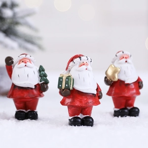 Three Nordic resin Santa Claus figurines with gifts in snowy Christmas scene