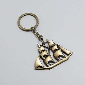 Detailed close-up of a vintage bronze sailing ship keychain with nautical anchor details