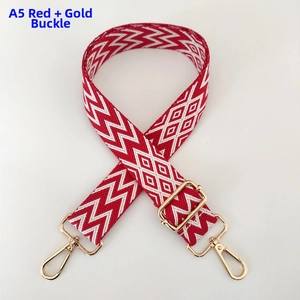 Detail of red wave pattern woven bag strap with polished gold-tone metal swivel hooks
