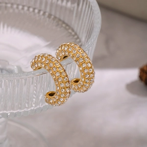 Vue détaillée de boucles d'oreilles en C plaquées or 18K avec pavage de zircons étincelants