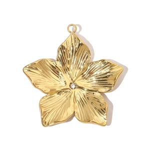 Macro shot of gold-plated flower pendant with engraved texture and center rhinestone