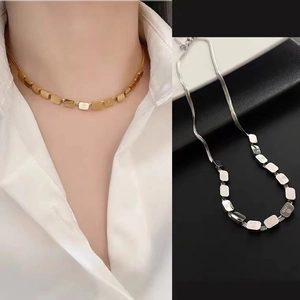 Gold and silver stainless steel LOVE block necklaces shown on model and flat lay view