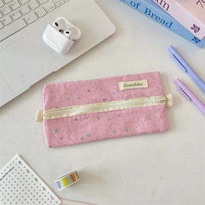 Detailed shot of pink canvas stationery pouch with silver stars and brand woven label