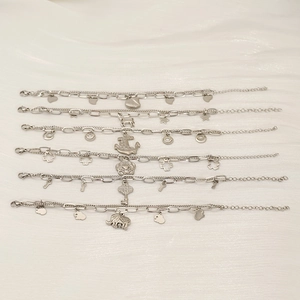 Detailed view of six silver double-layer stainless steel bracelets with various charms