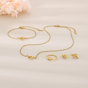 Macro detail of the 18K gold-plated knotted jewelry set with necklace and ring