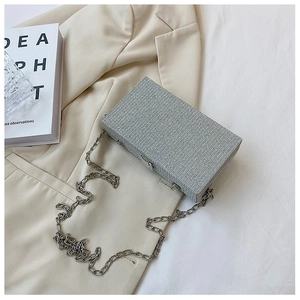 Detail of silver camera-shaped clutch with glitter texture and metallic chain strap