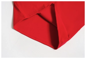 Détail de l'ourlet du haut de yoga rouge montrant la double couture sur le tissu brossé