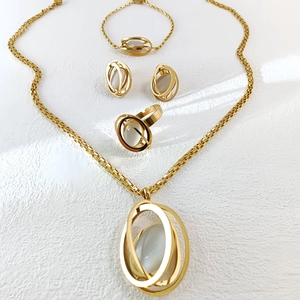Detail view of the four-piece gold jewelry set featuring white opal stones and hollow designs