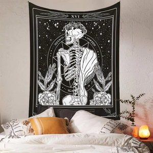 Bohemian black and white skull tarot tapestry hanging in a cozy bedroom setting