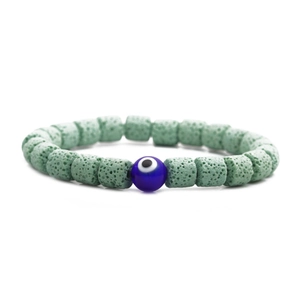 Nahaufnahme der porösen grünen Lavasteinperlen und des blauen Evil-Eye-Anhängers am Armband