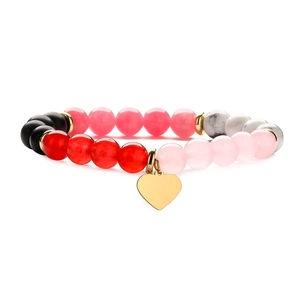 Detail of colorful stone beaded bracelet with gold heart charm and marble texture beads