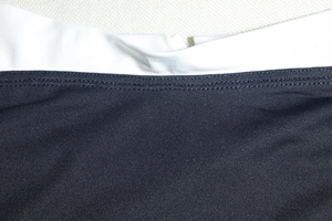 Dettaglio delle cuciture a contrasto bianco e nero e della trama in maglia dell'abito