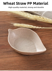 Leaf-shaped dipping saucer made of natural wheat straw material on a wooden surface