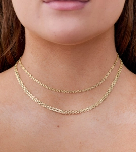 Gros plan de bracelets double épaisseur en acier inoxydable doré 18 carats sur un modèle