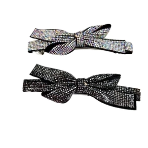 Detailed close-up of sparkling crystal rhinestone bow hair clips in silver and black colors