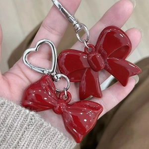 Detailed view of red acrylic bow pendants with silver heart-shaped and D-type clasps