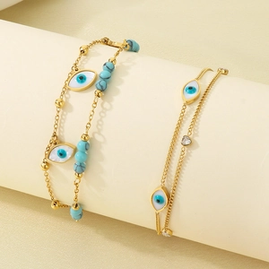 Gold layered evil eye anklet with turquoise beads and heart charms on a display