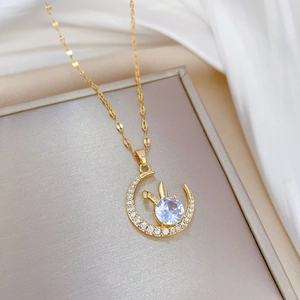 Luxury gold titanium necklace with sparkling moon rabbit pendant on a beige jewelry box