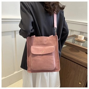 Detail of pink corduroy tote bag featuring an external pocket and shoulder strap