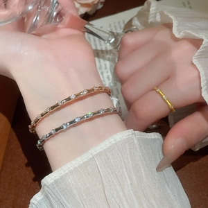 Macro shot of bamboo-style zircon bracelets and ring set worn on model wrist