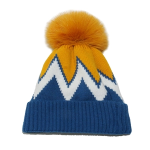 Berretto invernale con pompon giallo e motivo geometrico a zigzag su sfondo bianco