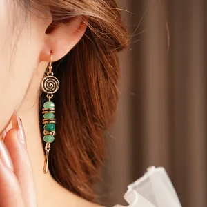 Bohemian vintage long drop earrings with green faceted beads on a female model