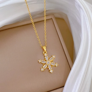 Elegante goldene Schneeflocken-Halskette mit funkelnden Kristallen auf Schmuckkästchen