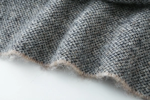 Macro detail of high-quality brushed jacquard knit fabric with soft wool-like texture