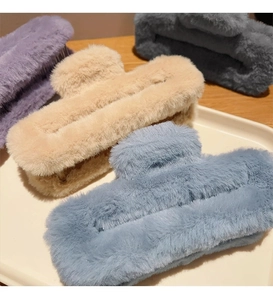 Detail view of large plush hair claws in khaki blue purple and grey soft textures