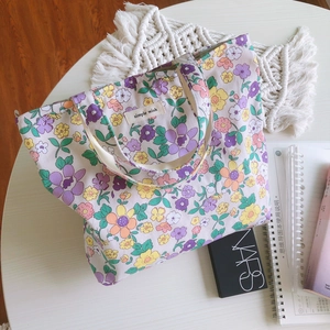 Petit sac en coton à fleurs avec étiquette 'simple wish' posé sur une table blanche