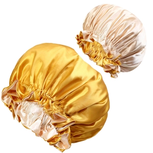 Dettaglio delle cuffie da notte in raso color oro e champagne con bordo elastico