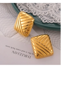 Détail de boucles d'oreilles carrées en titane plaqué or avec texture tressée diagonale