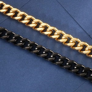 Close-up of gold and black polished flat curb chains with classic Cuban link design