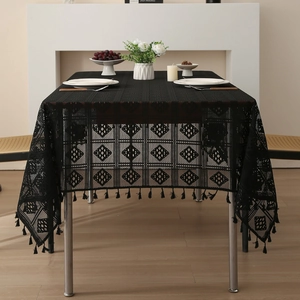 Nappe élégante en dentelle noire avec motifs géométriques et franges sur une table à manger