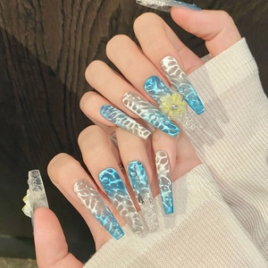 Blue ocean-style press-on nails with 3D water droplets and yellow floral nail art