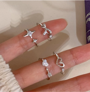 Close-up of four-piece silver adjustable rings featuring heart and bow designs