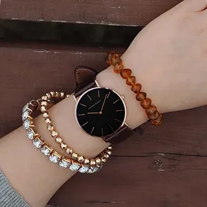 Hannah Martin women's minimalist quartz watch with brown leather strap and layered bracelets