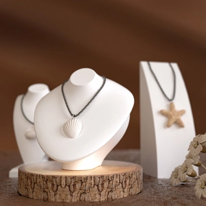 Detail of seashell and starfish necklaces on white resin busts and display stands