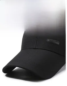 Detail of a black baseball cap featuring an extended brim and fashion tag on twill fabric