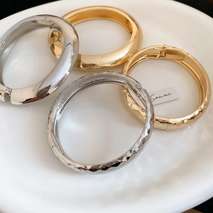 Vue détaillée de bracelets métalliques dorés et argentés avec texture martelée