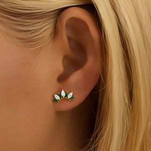 Detailed view of an emerald and crystal flower cartilage stud earring on a model