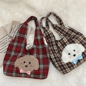 Detail of cute plush puppy embroidery on red and brown plaid canvas tote bags