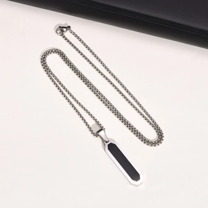 Macro view of geometric stainless steel necklace with black rectangle pendant detail