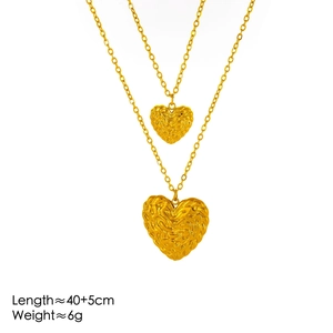 Golden double-layer necklace with textured heart pendants on a clean white background