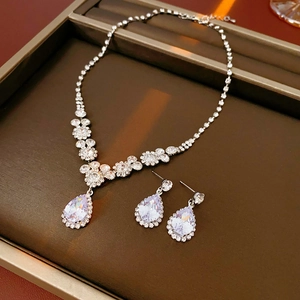 Gros plan d'un ensemble collier et boucles d'oreilles en zircone argentée en goutte