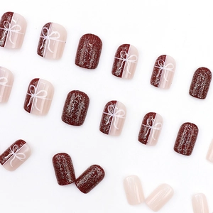 Short round deep red and beige press-on nails set with glitter on a white background