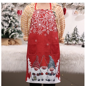 Close-up of festive red linen-style apron featuring Christmas gnome patterns and pockets