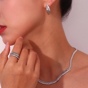 Detailed view of silver herringbone pattern jewelry set with sparkling white crystals