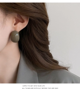 Boucle d'oreille en résine olive en forme de haricot sur mannequin, texture lisse